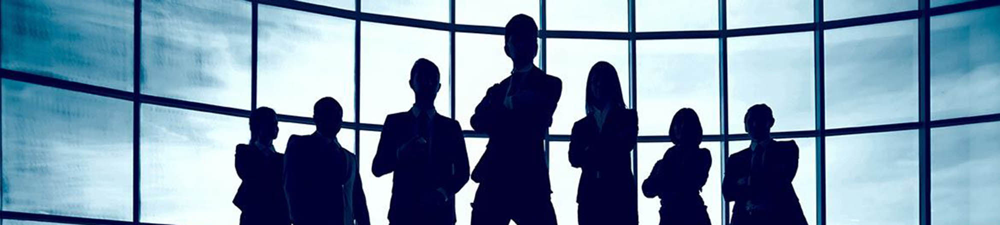 Business team standing against window with leader in front